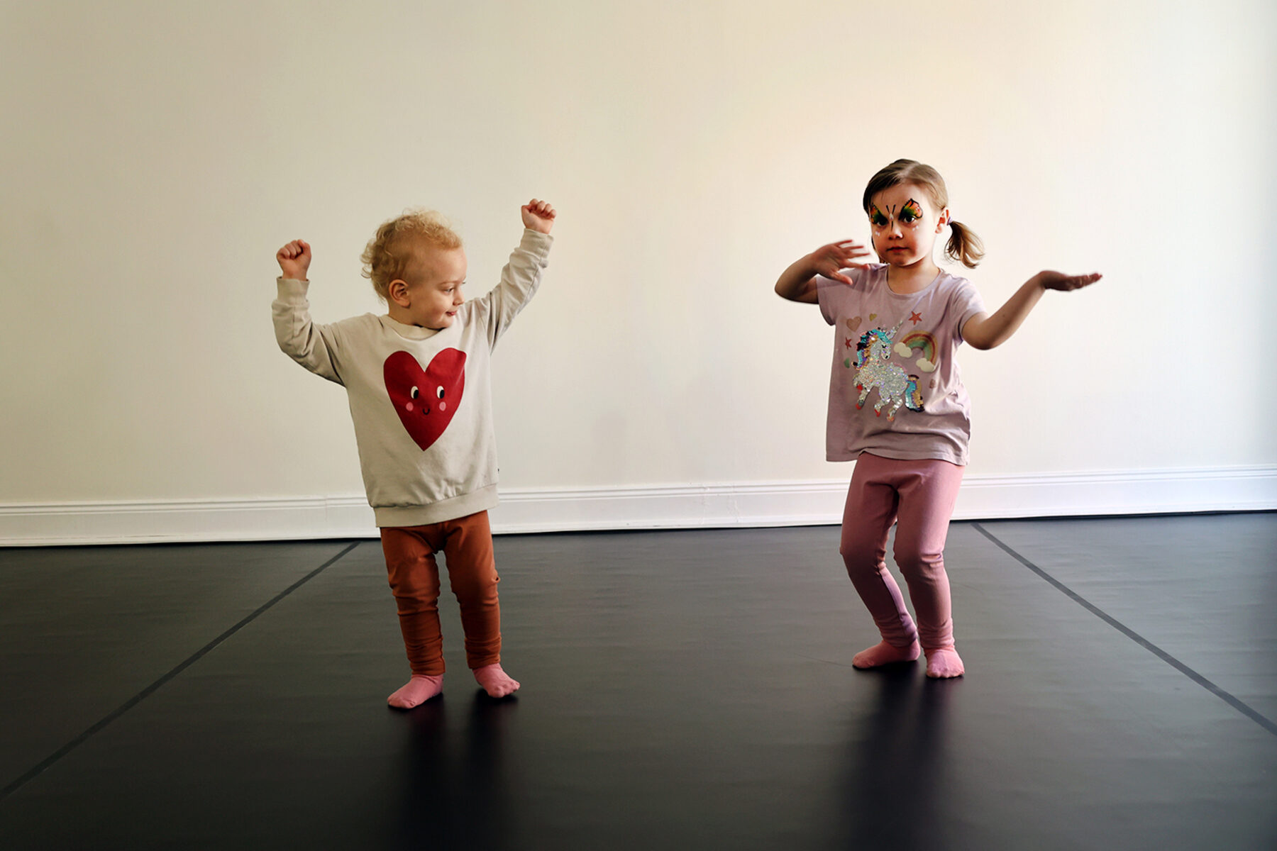 Två barn dansar tillsammans i SAND-studion